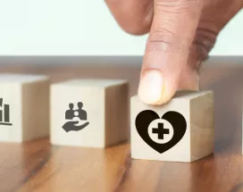 Image shows a hand grabbing a block with a heart on it.