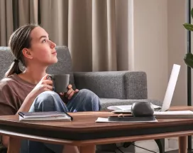 An employee exhibiting work-life balance by working remotely in her living room 