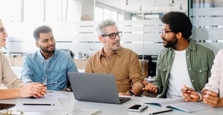 Team of engaged employees collaborating in a modern office, showing how culture helps retain talent