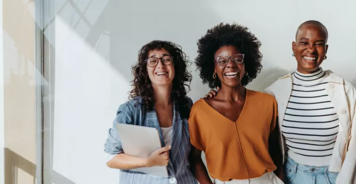 three employees smiling at the camera