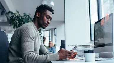 guy at desk using cell phone