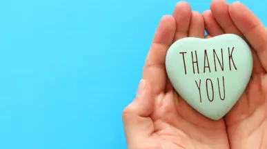 Image shows two hands cupped together with a heart in the middle that says "Thank You"