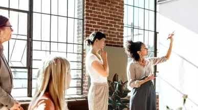 A group of colleagues brainstorming at a white board