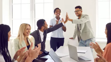 Two employees high fiving over a table