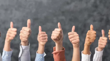 Image shows a bunch of people giving a thumbs up