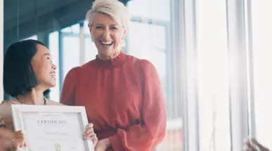 Image shows a leader presenting an employee award to a team member.