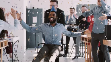 Image shows a person celebrating at an office party