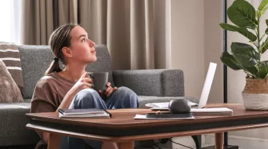An employee exhibiting work-life balance by working remotely in her living room 