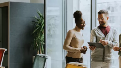 A group of employees working collaboratively together on an tablet.