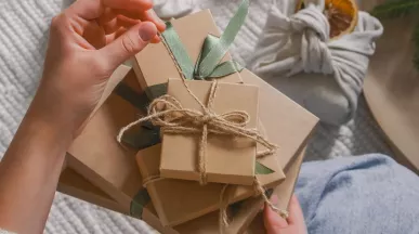 A HR professional manually wrapping a reward for their employee recognition program.