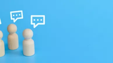 Three wood figurines giving feedback with text boxes over their head